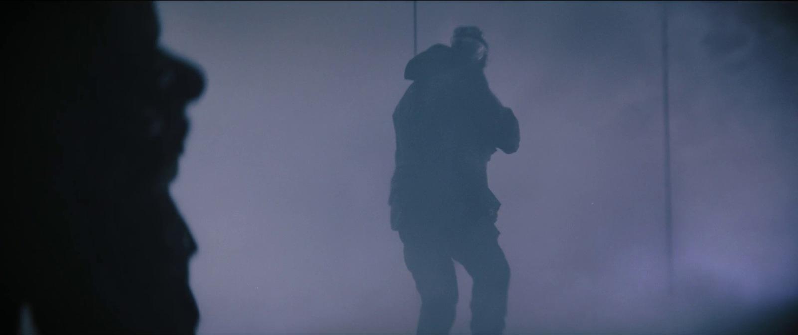 a person standing in a foggy room with a cell phone