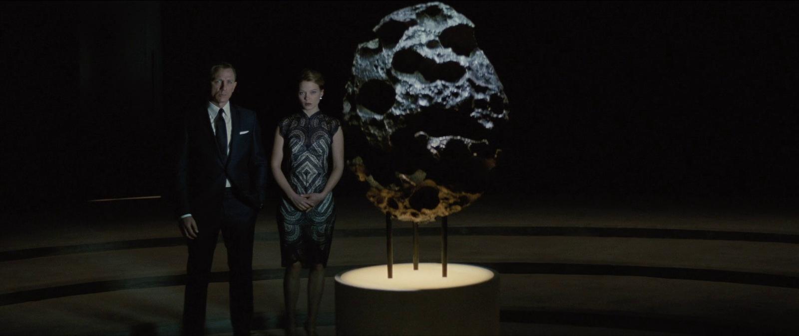a man and a woman standing in front of a sculpture