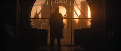 a man standing in front of a window in a dark room