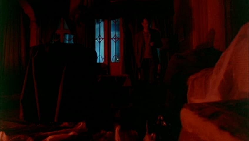 a dark room with a bed and a window
