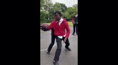 a man in a red jacket is holding a basketball