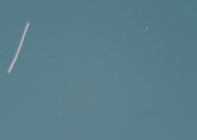 a plane flying in the sky with a contrail in the sky