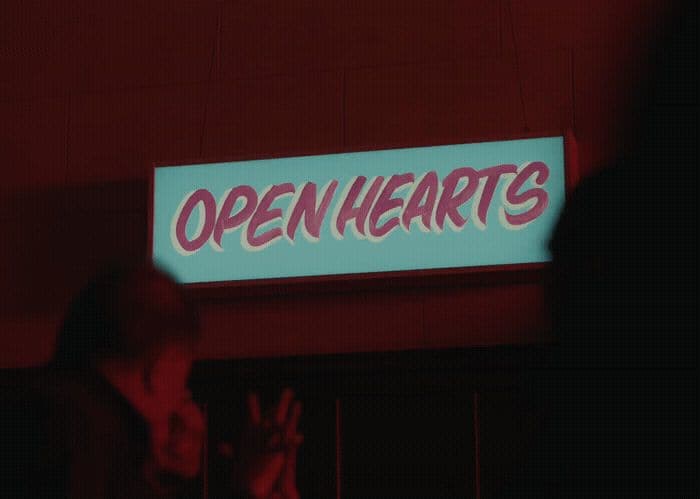 a neon sign that says open hearts on it