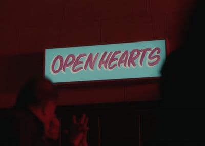 a neon sign that says open hearts on it