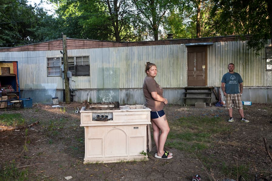 a woman standing next to a stove in a yard