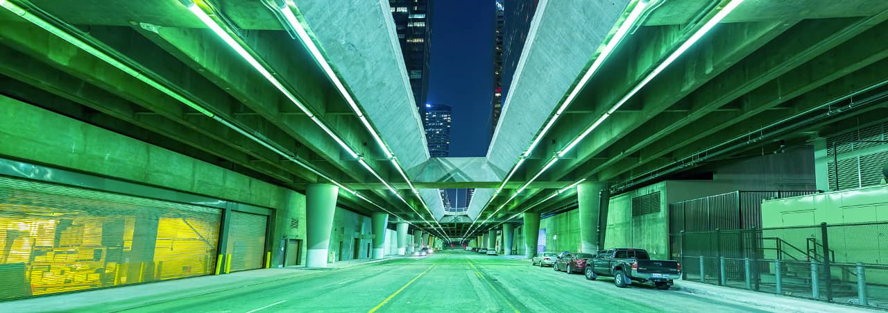a city street at night with cars parked on the side of the road