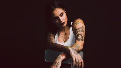 a woman with tattoos sitting in a chair