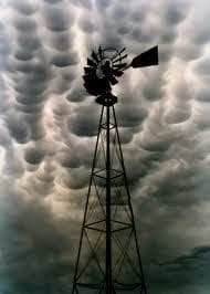 a windmill in the middle of a cloudy sky