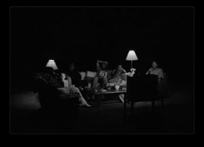 a group of people sitting around a table in the dark
