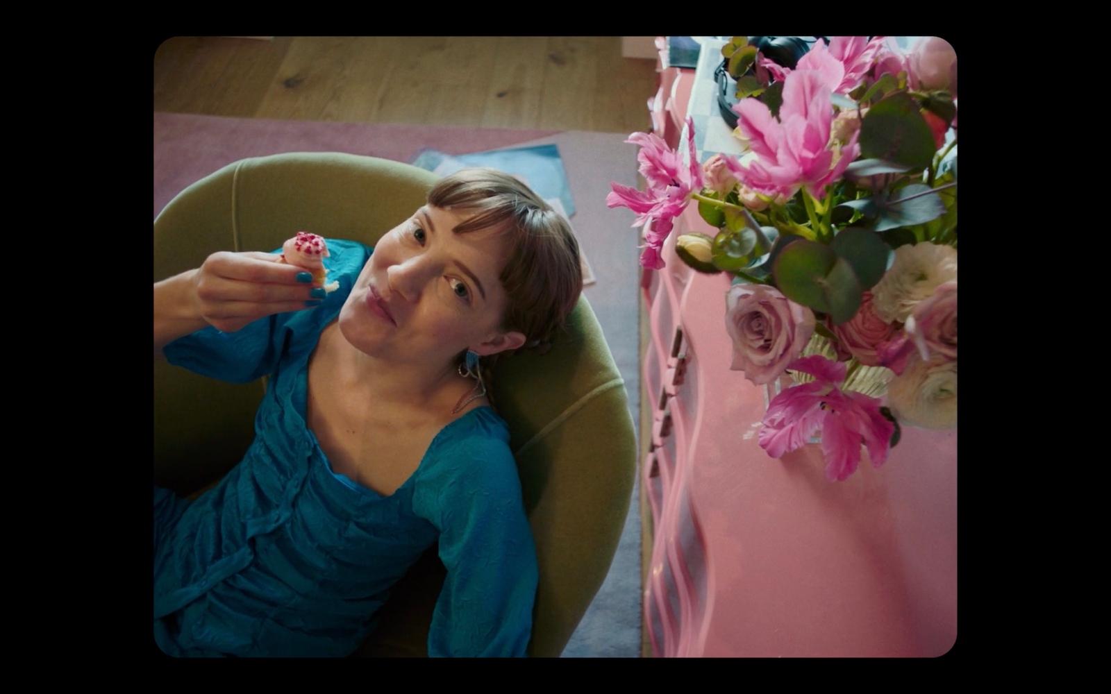 a woman sitting in a chair next to a vase of flowers