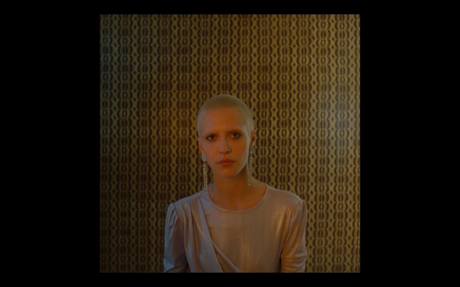 a woman standing in front of a wall with circles on it