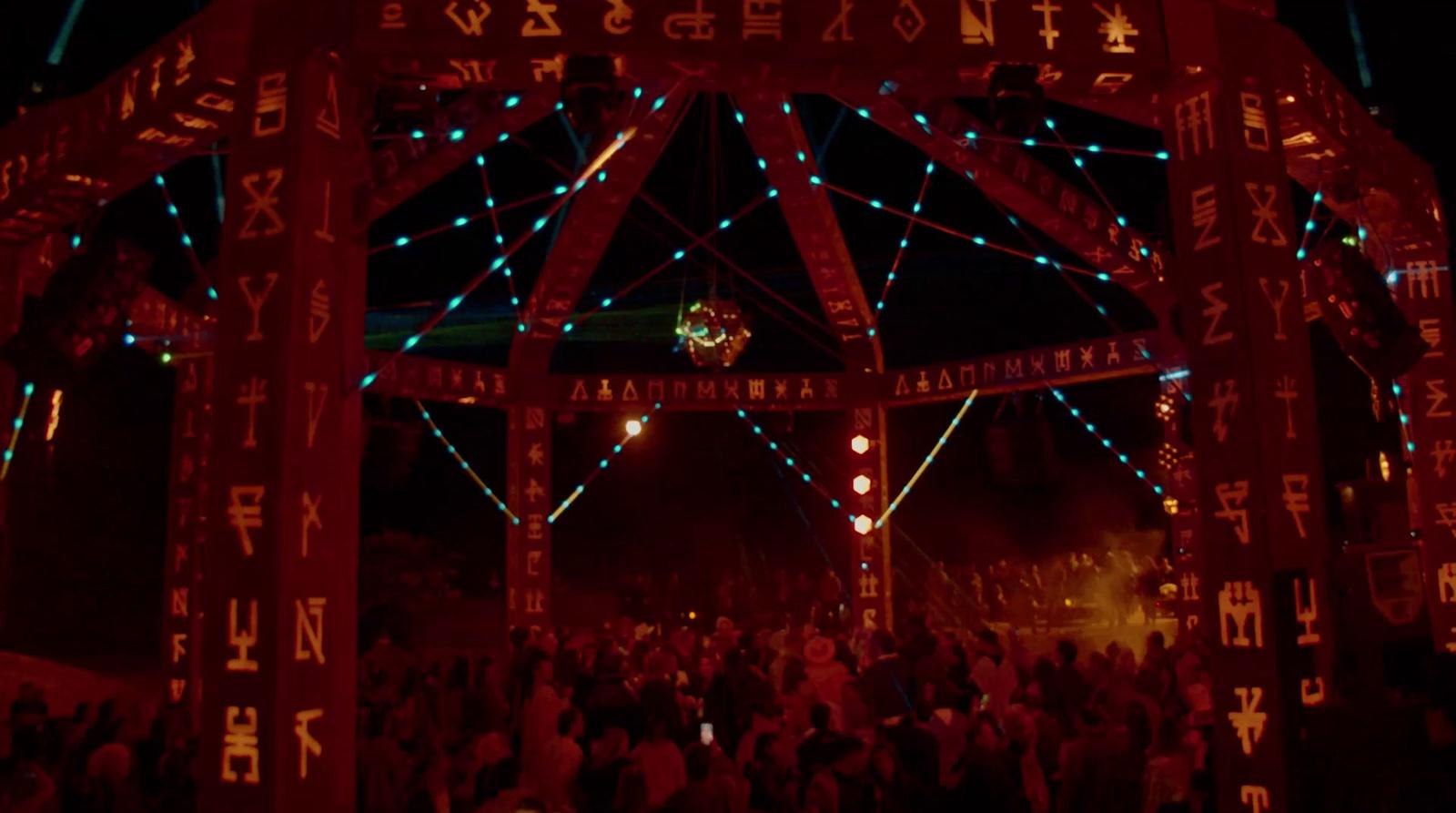 a group of people standing under a lit up structure