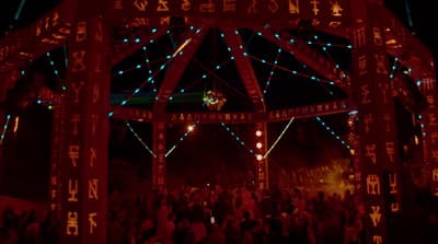 a group of people standing under a lit up structure