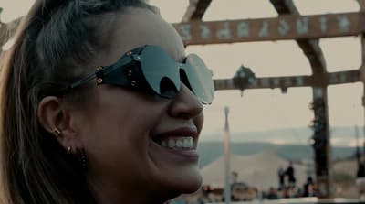 a woman wearing a pair of sunglasses smiling