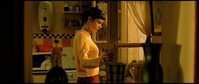 a woman standing in a kitchen next to a window