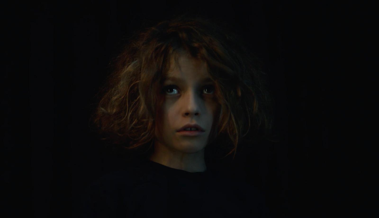 a woman with long hair standing in the dark