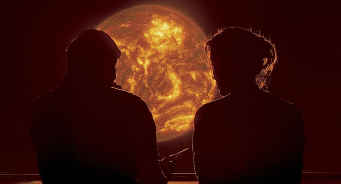 a couple of people standing in front of a sun