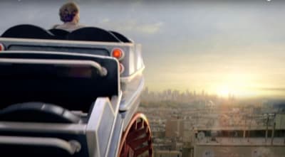 a man sitting on top of a bus looking out over a city
