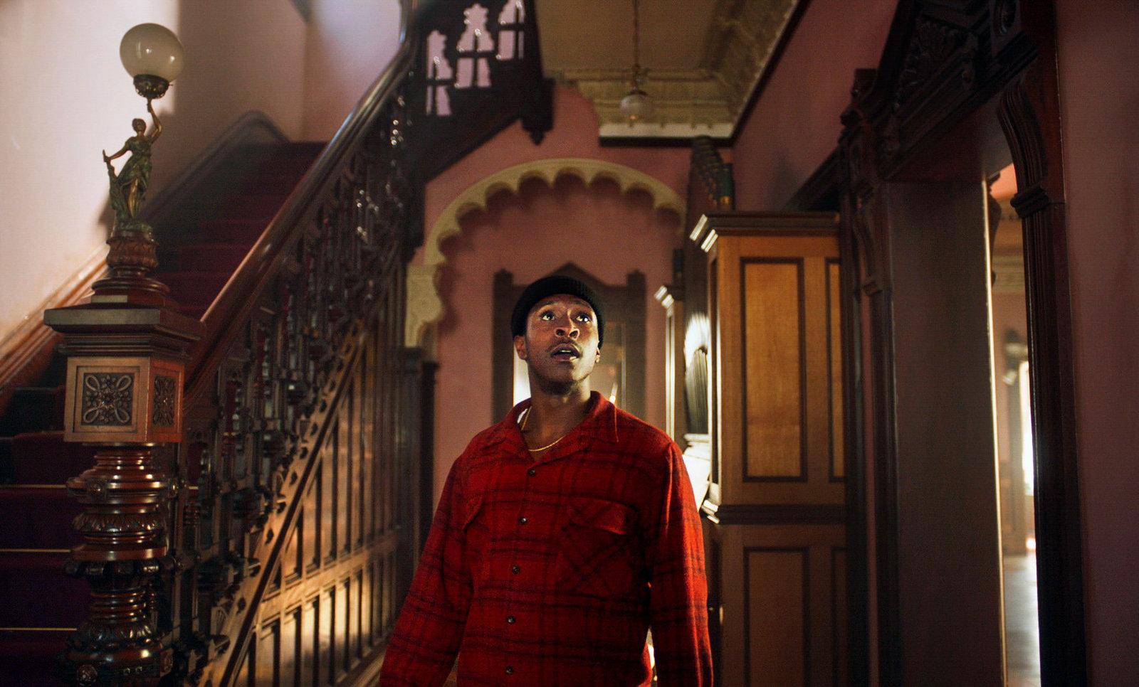 a man in a red shirt standing in a hallway