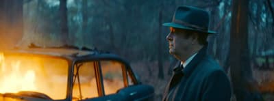 a man in a top hat standing next to a car