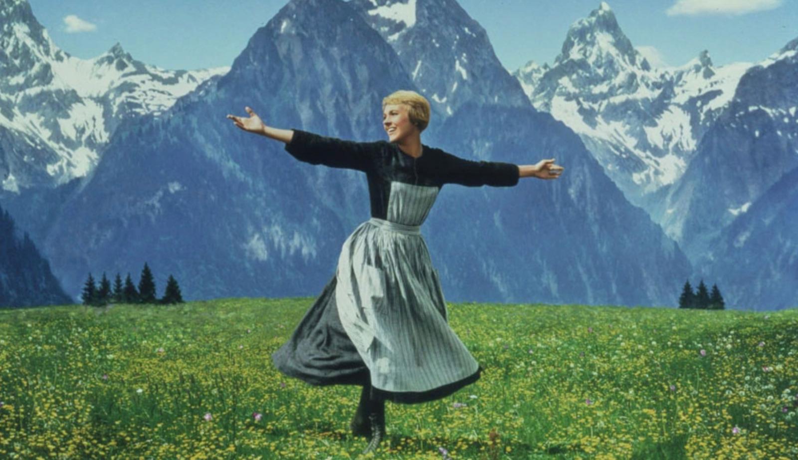a woman in a field with mountains in the background