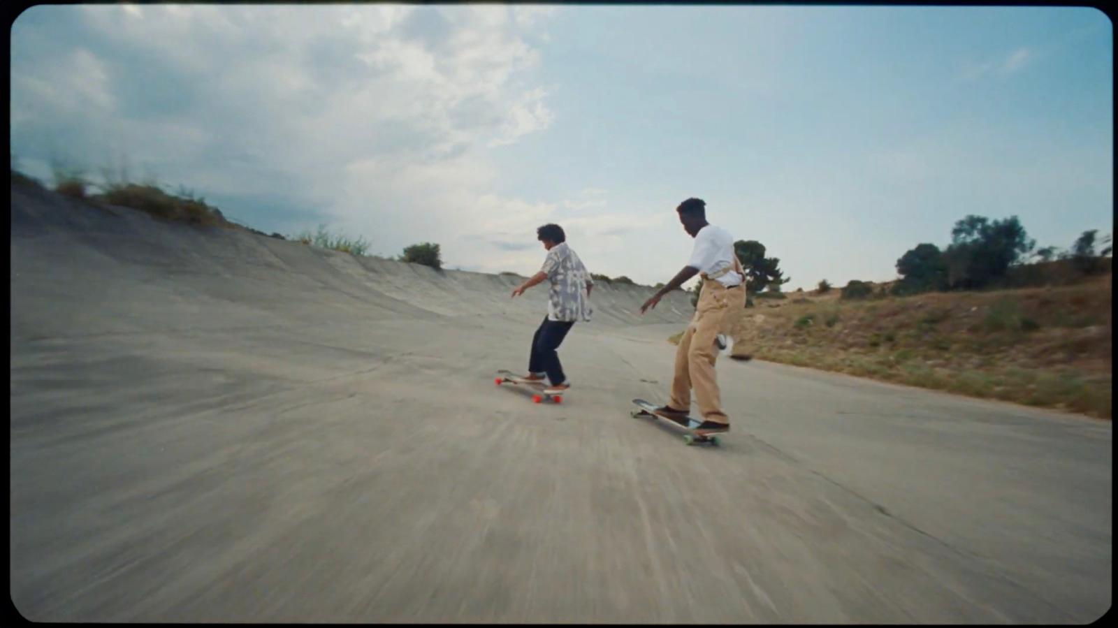 a couple of men riding skateboards down a street
