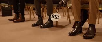 a group of people sitting in chairs with a sign in front of them