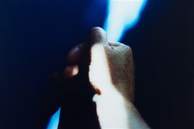 a person's hand holding something in the dark