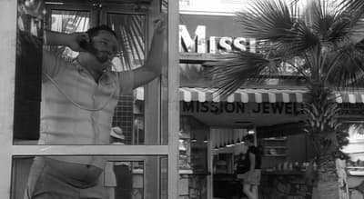 a black and white photo of a man talking on a phone