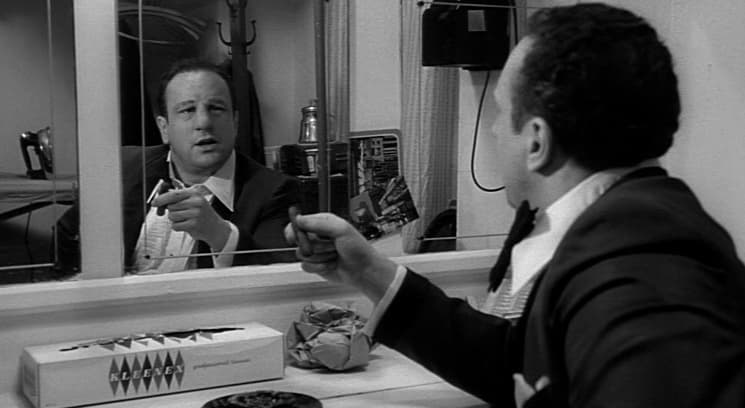 a man sitting at a table in front of a mirror