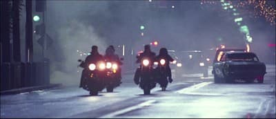 a group of people riding motorcycles down a street