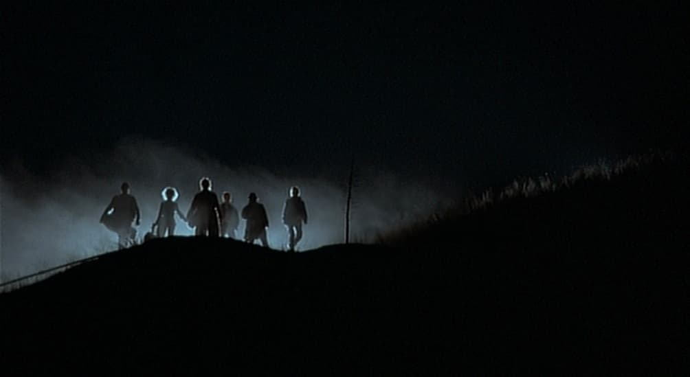 a group of people standing on top of a hill
