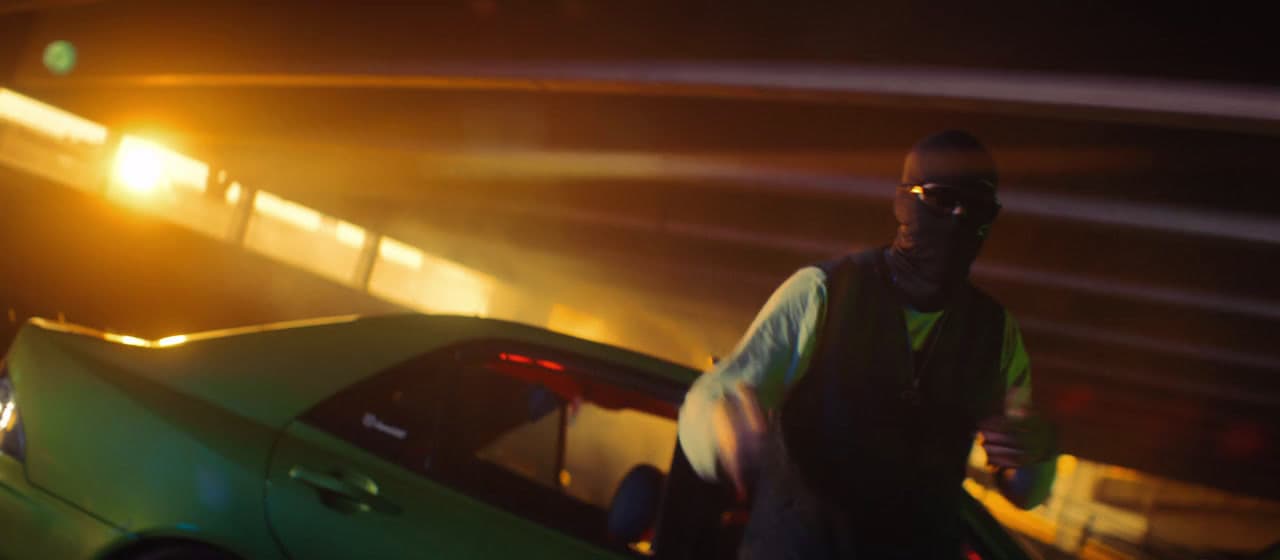 a man standing next to a green car at night
