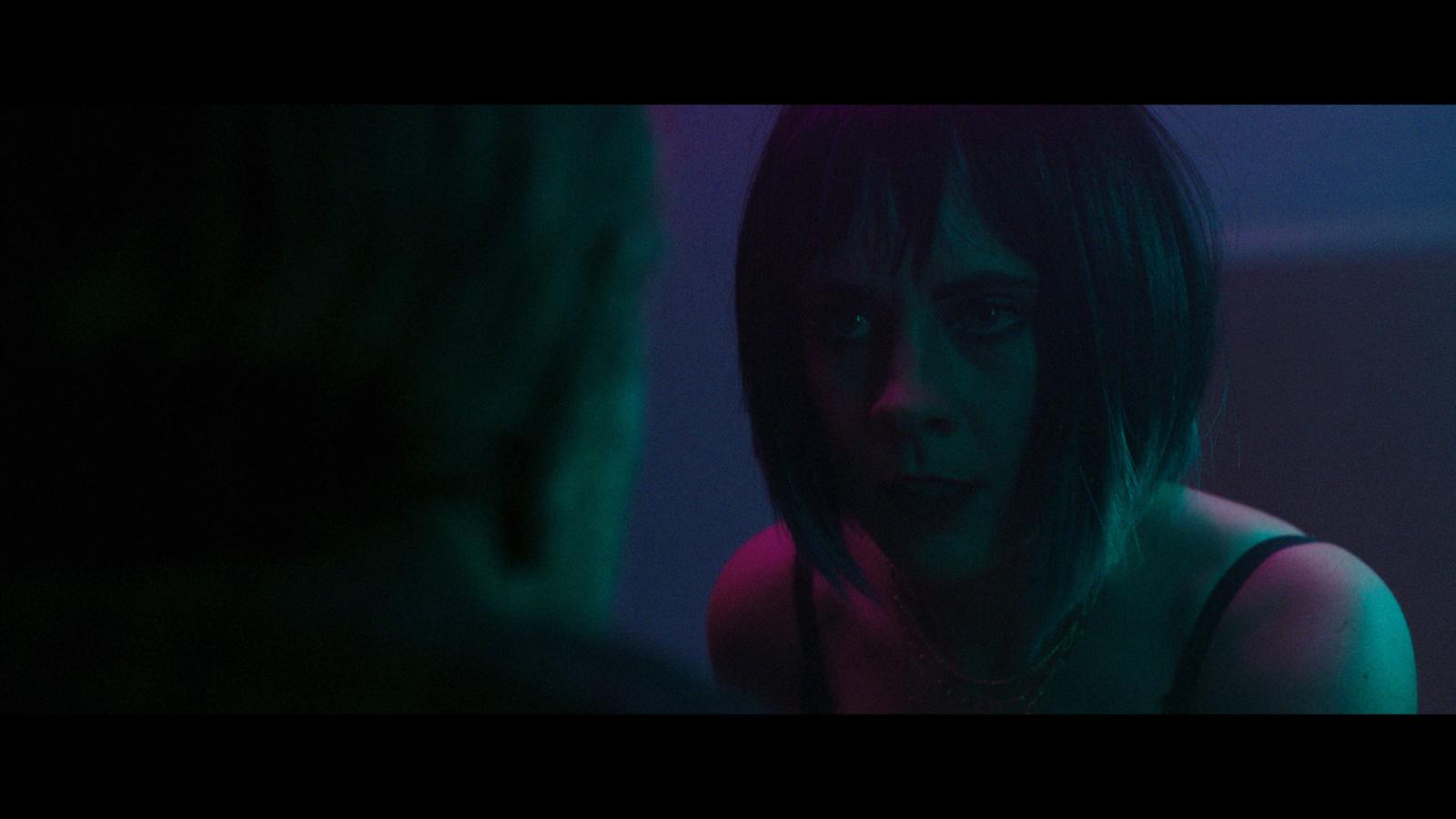 a woman in a dark room looking at a man
