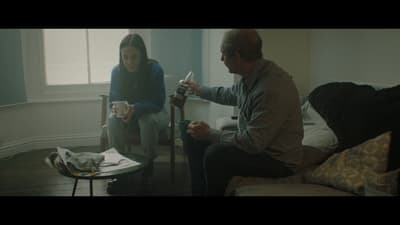 a man sitting on a couch next to a woman