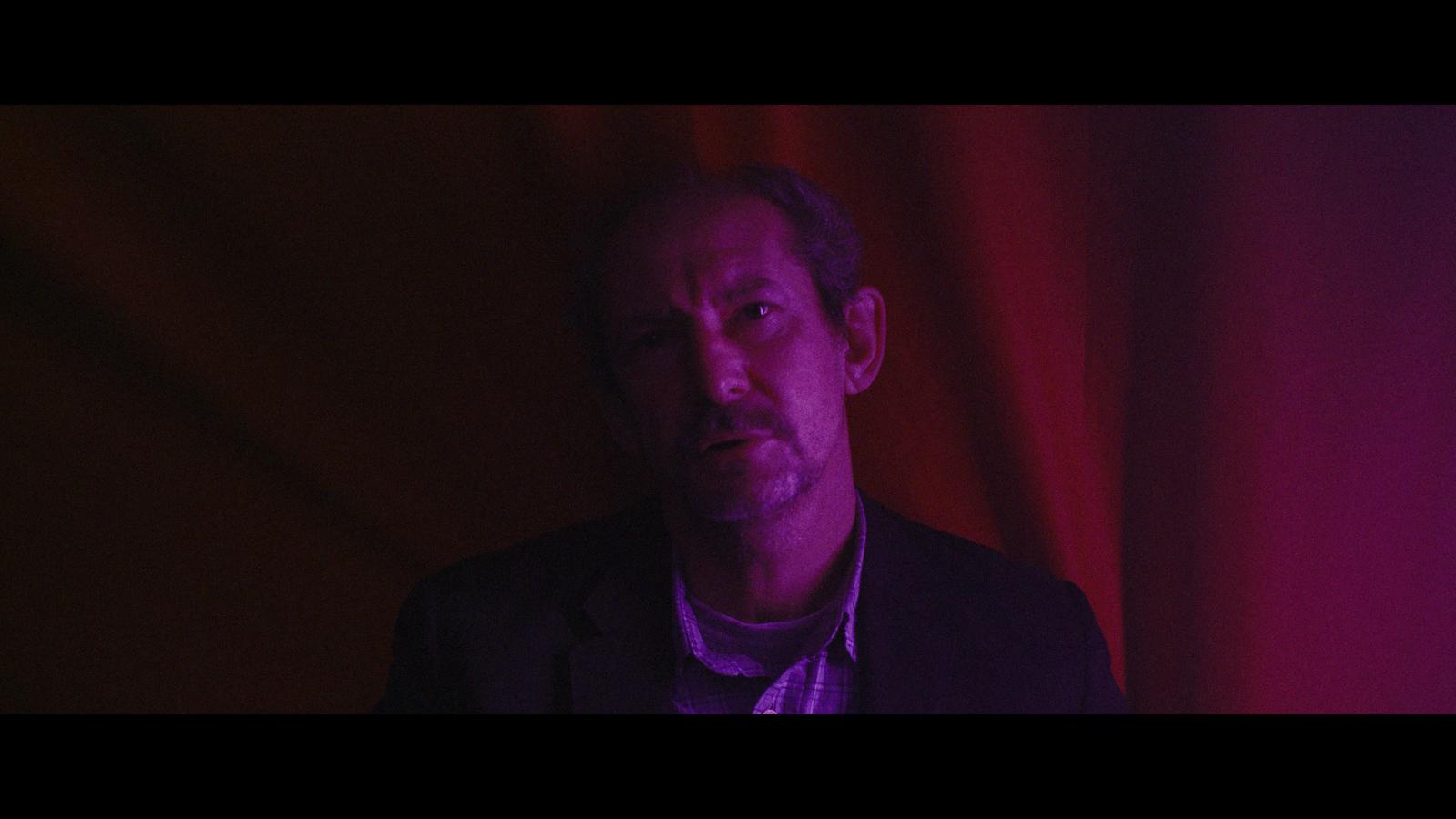 a man standing in front of a red curtain
