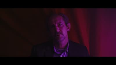 a man standing in front of a red curtain