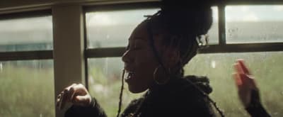 a woman standing in front of a window holding a cell phone