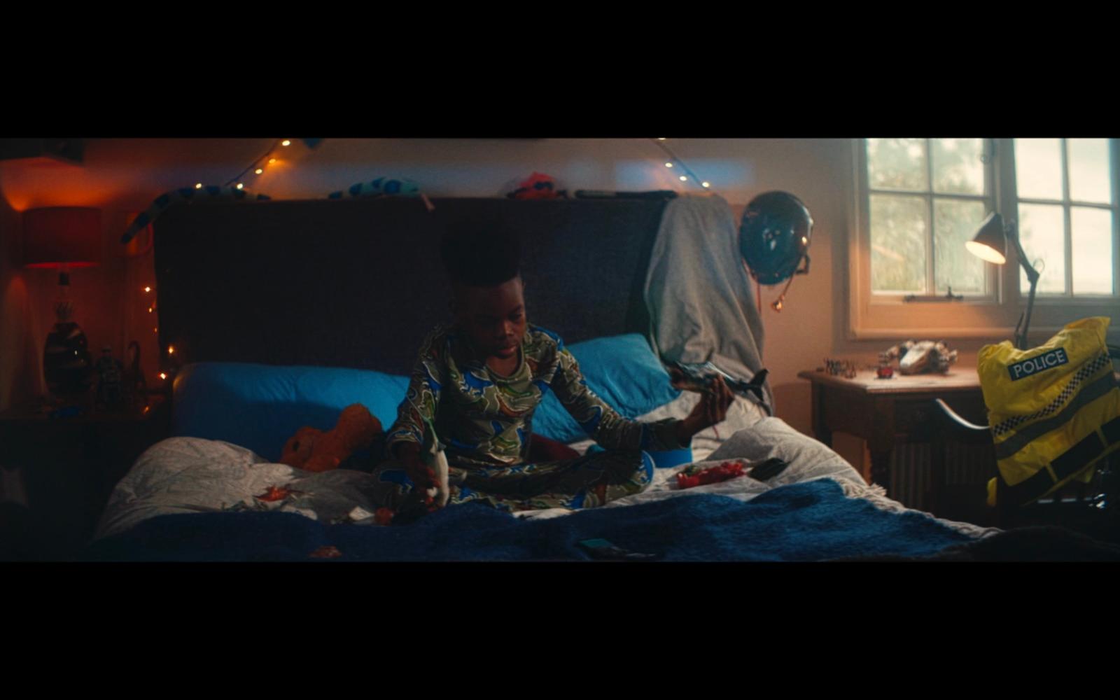 a child sitting on a bed with a stuffed animal