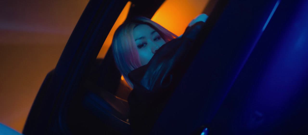 a young girl with blonde hair looking into a mirror