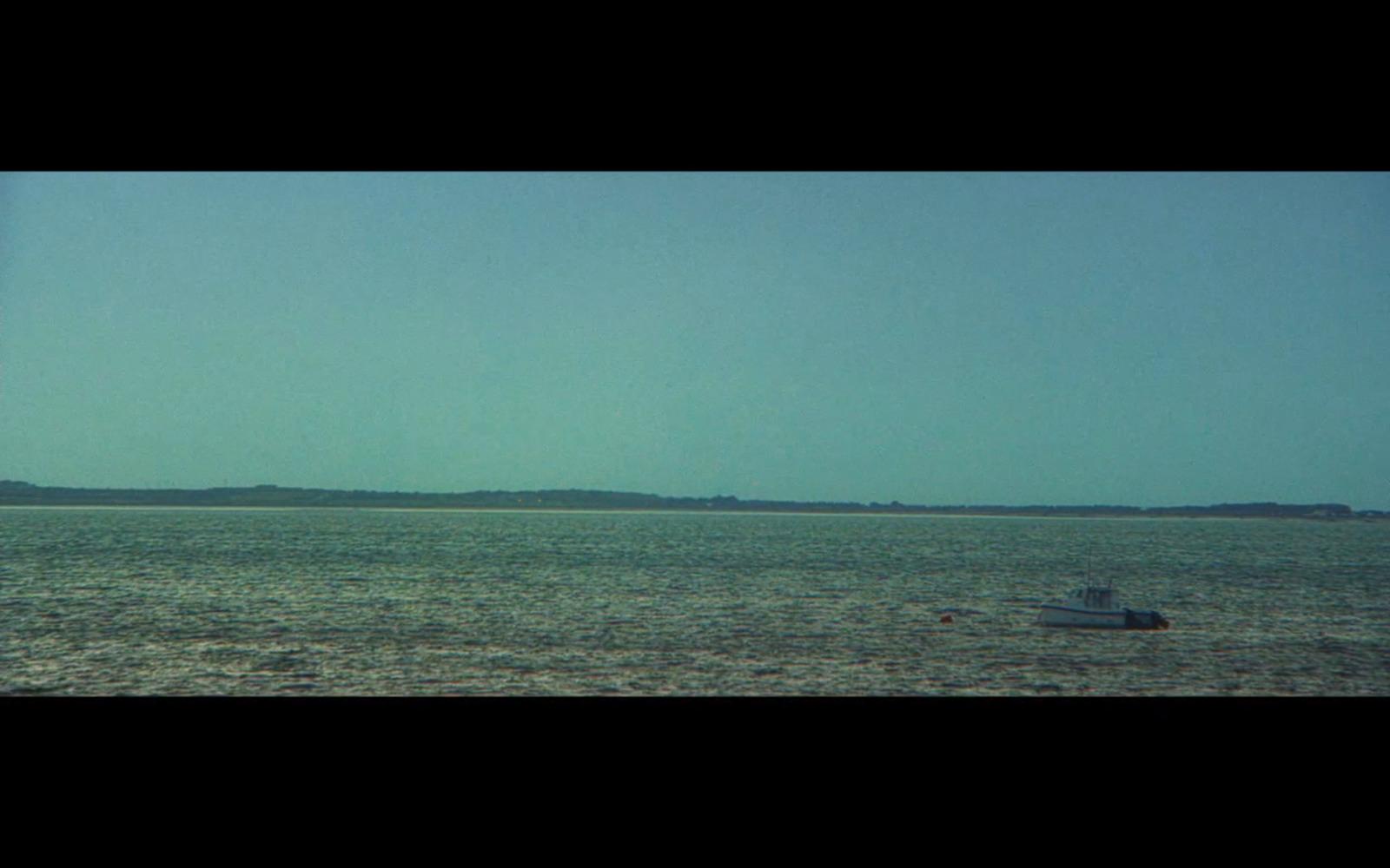 a small boat floating on top of a large body of water