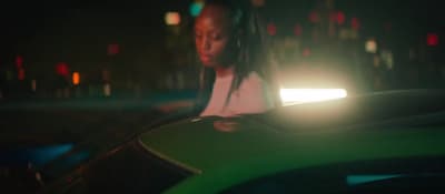 a woman sitting on top of a green car