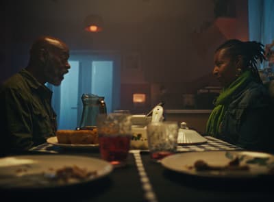 a man and a woman sitting at a table with plates of food