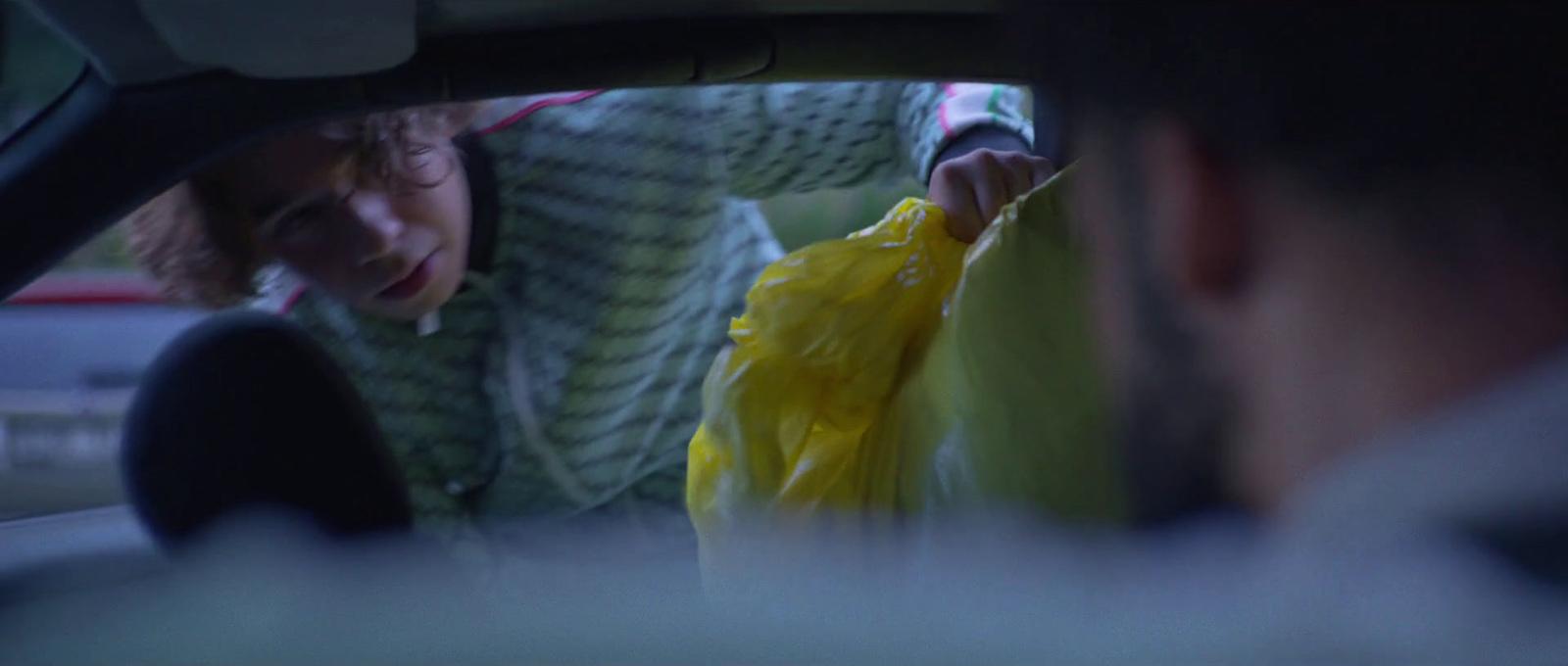 a woman holding a yellow bag in a car