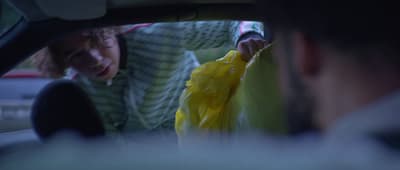 a woman holding a yellow bag in a car