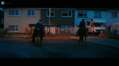 a couple of people riding on the backs of horses