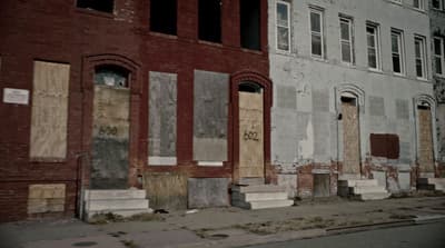 a row of boarded up buildings on a city street