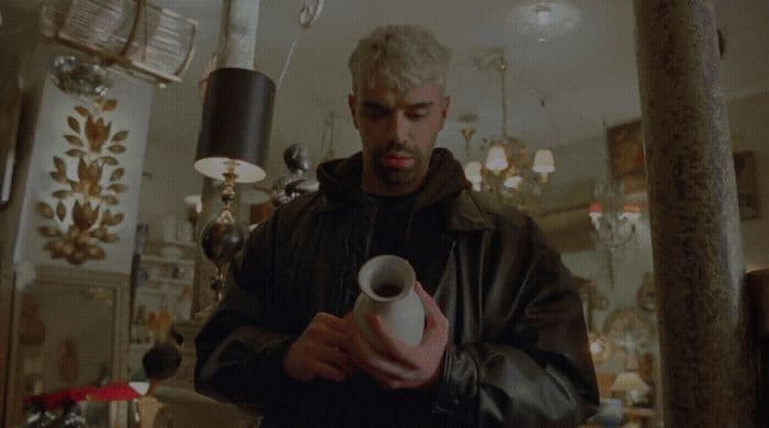 a man holding a white vase in a room
