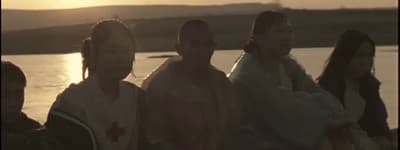 a group of people standing next to each other near a body of water