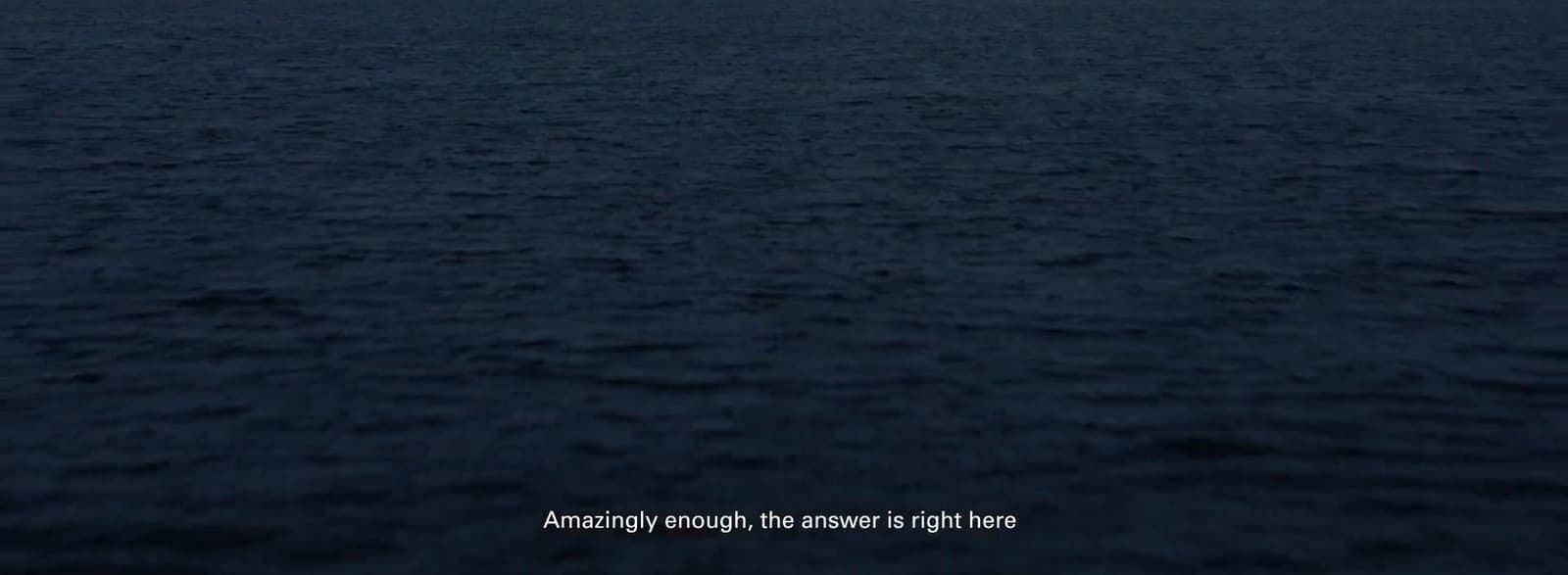 a large body of water with a boat in the distance